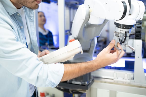 Close-up of young male engineers hand touching machine